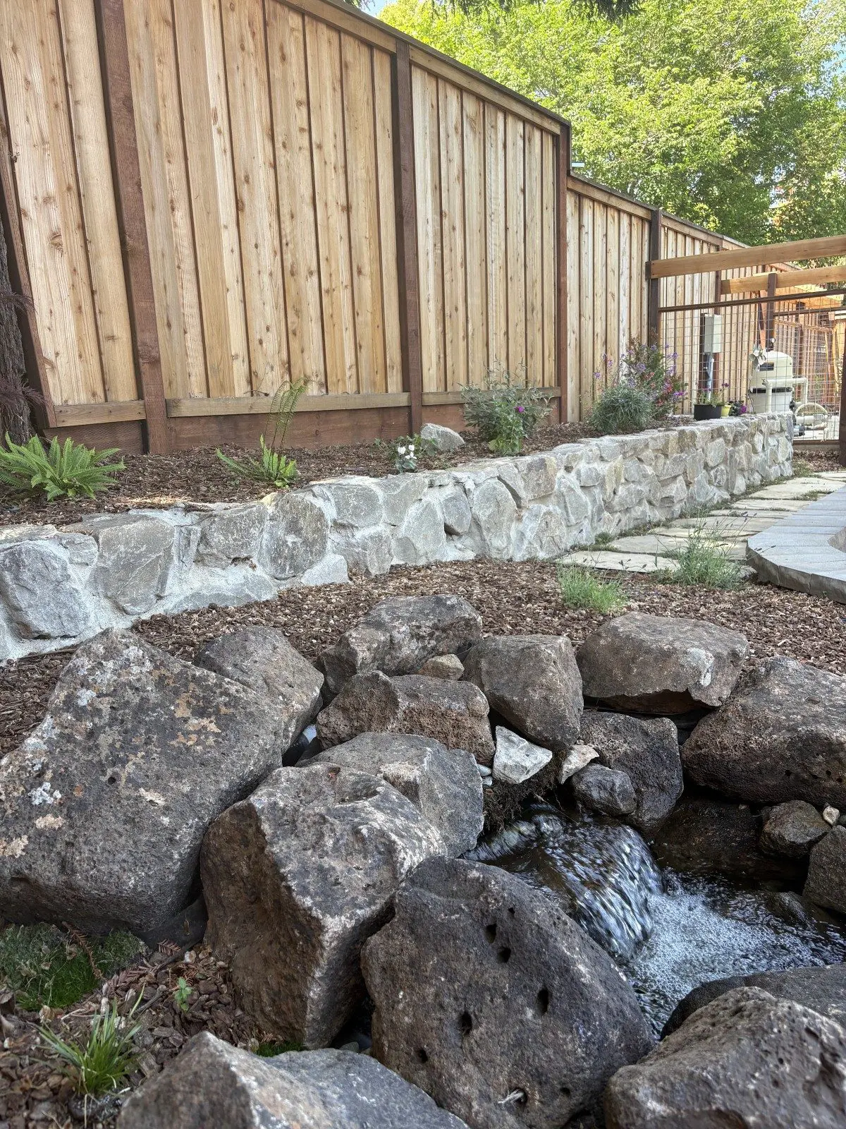 Custom stone water feature and stream installation for Exterior Plumbing & Irrigation services in Napa, CA.