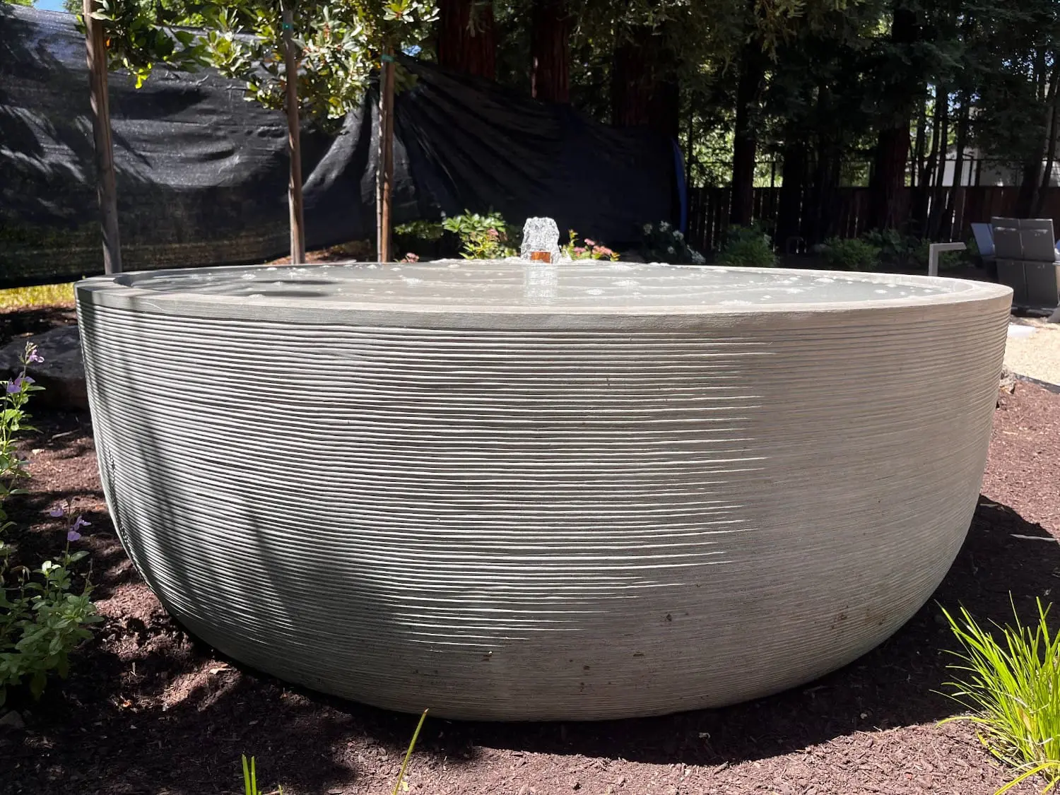 Modern round concrete water feature and custom exterior plumbing installation in Napa, CA by Keystone Yards.