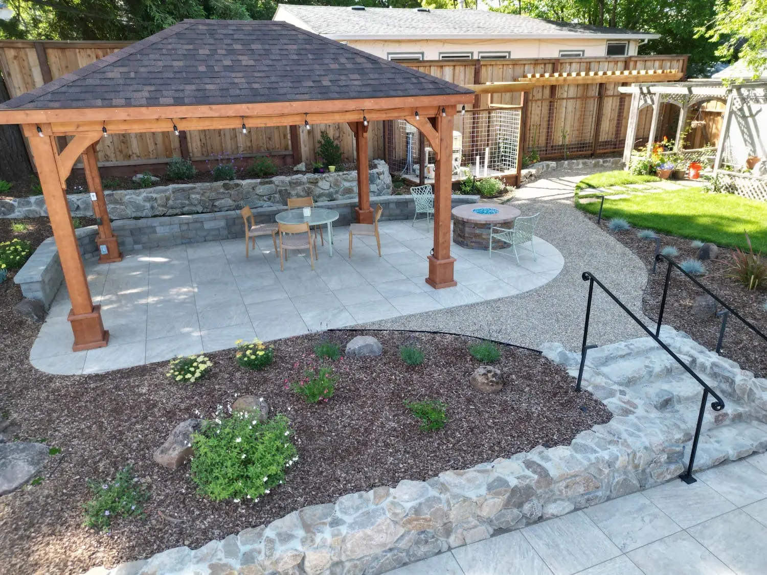 Custom wooden pergola and gazebo installation over a paved patio in a Napa, CA backyard.