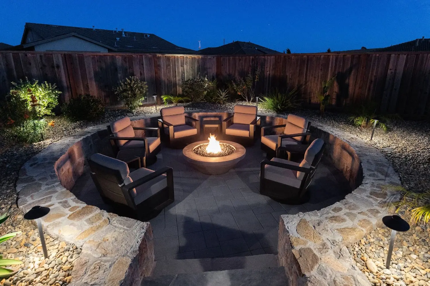 Custom stone fire pit with patio seating and professional outdoor landscape lighting in Napa, CA.