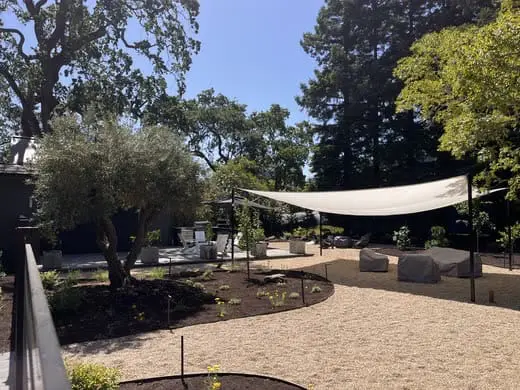 Outdoor shade sail installation and gravel landscaping in a Napa, CA backyard.