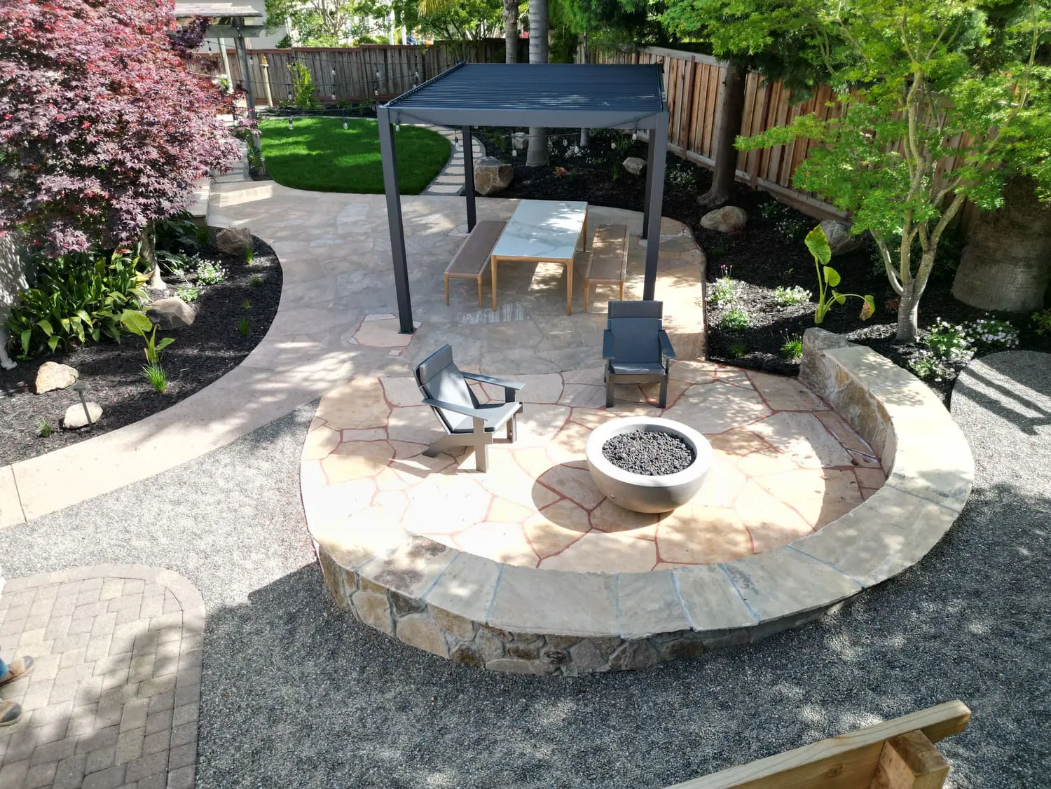 Custom circular stone patio with fire pit and outdoor lounge seating designed by keystone-yards-novato-ca