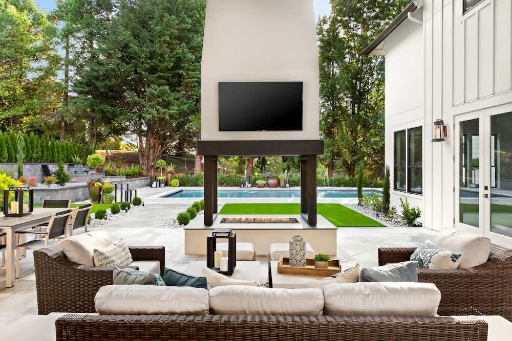 Outdoor fireplace, pool, in back yard of luxury home
