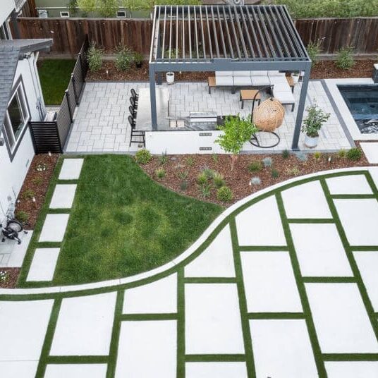 Aerial view of a backyard landscape design in Napa, CA with pergola, pavers, turf, and pool