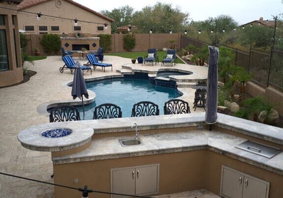 Luxury backyard with custom pool, outdoor kitchen, and stone patio showing how to choose an outdoor contractor for luxury outdoor projects